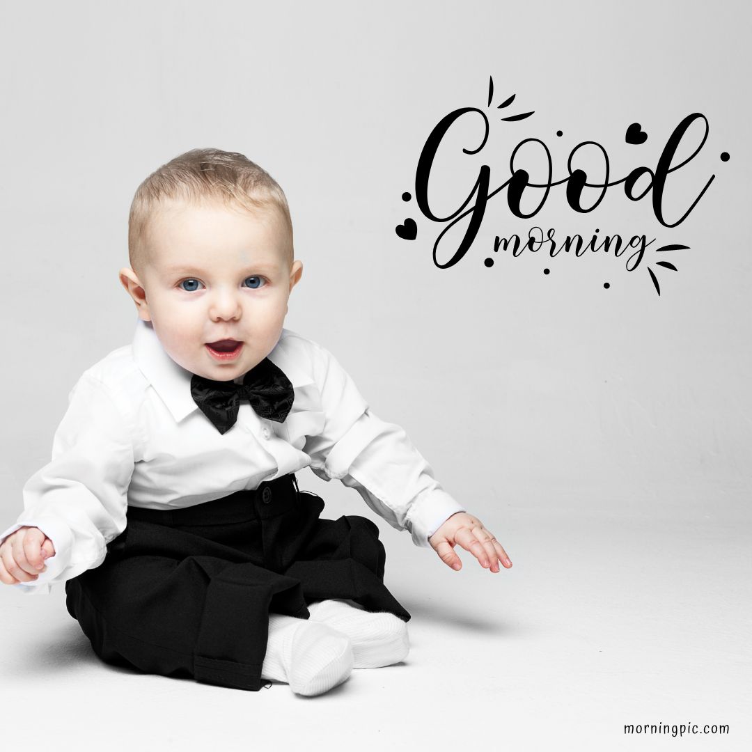 A baby dressed in a white shirt with a black bow tie and black pants is sitting on a white background. Text beside the baby reads "Good Morning Baby Girl" with decorative elements.