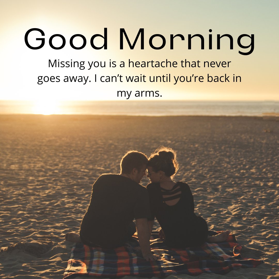 A couple sits on a blanket at the beach, facing each other with their foreheads touching as the sun sets in the background. The image includes the text 'Good Morning' and 'Missing you is a heartache that never goes away. I can’t wait until you’re back in my arms,' making it ideal for emotional missing you messages for a wife.