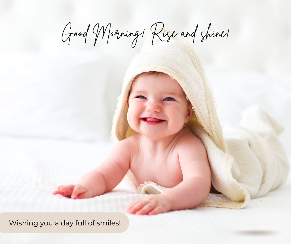 A smiling baby wrapped in a towel lies on a bed. Text above reads "Good Morning! Rise and shine!" and in the corner, "Wishing you a day full of smiles!” Perfect for those seeking Good Morning Baby Images HD.