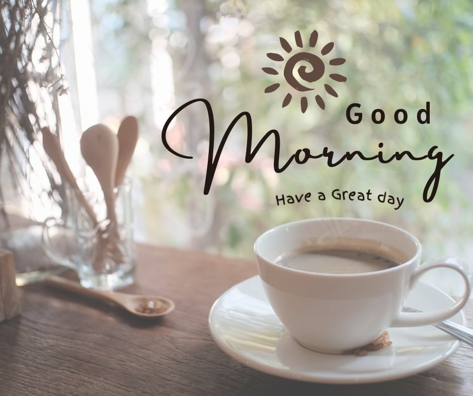 A white cup of coffee sits on a wooden table near a window with greenery outside. A small jar containing utensils is beside the cup. Text on the image reads "Good Morning" with a sun icon and "Have a Nice Day". Enjoy these peaceful morning images!