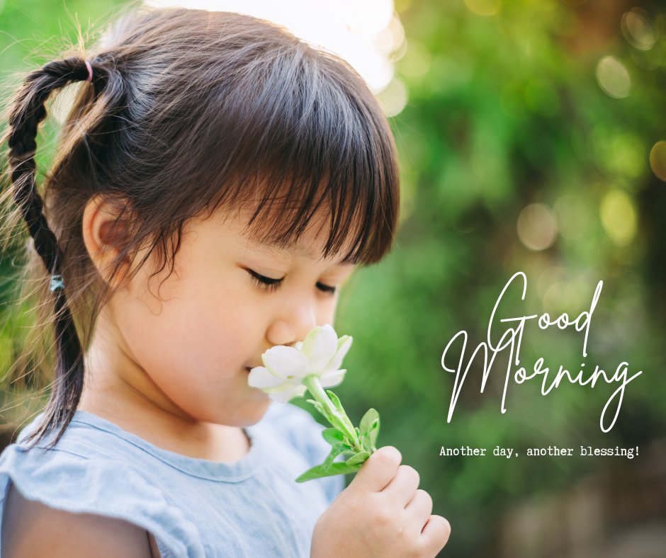 Good Morning Baby Images of a young girl with pigtails smelling a white flower in a sunlit garden, with the message 'Good Morning - Another day, another blessing!'