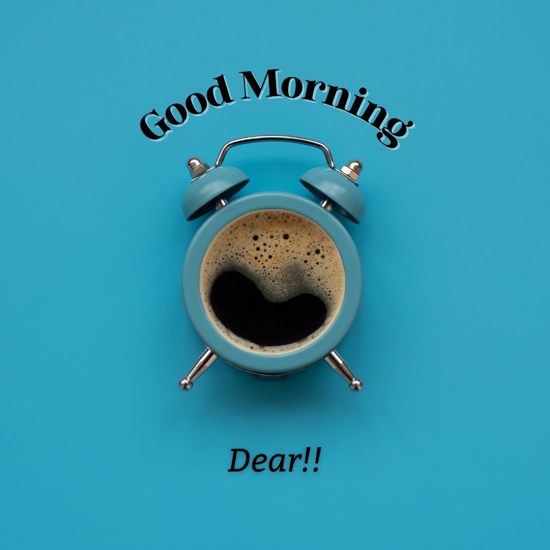 Good morning dear images showcasing a creative presentation with a blue alarm clock doubling as a coffee cup filled with fresh coffee on a bright blue background. The text 'Good Morning Dear!!' arches playfully above the clock, enhancing the cheerful morning theme.