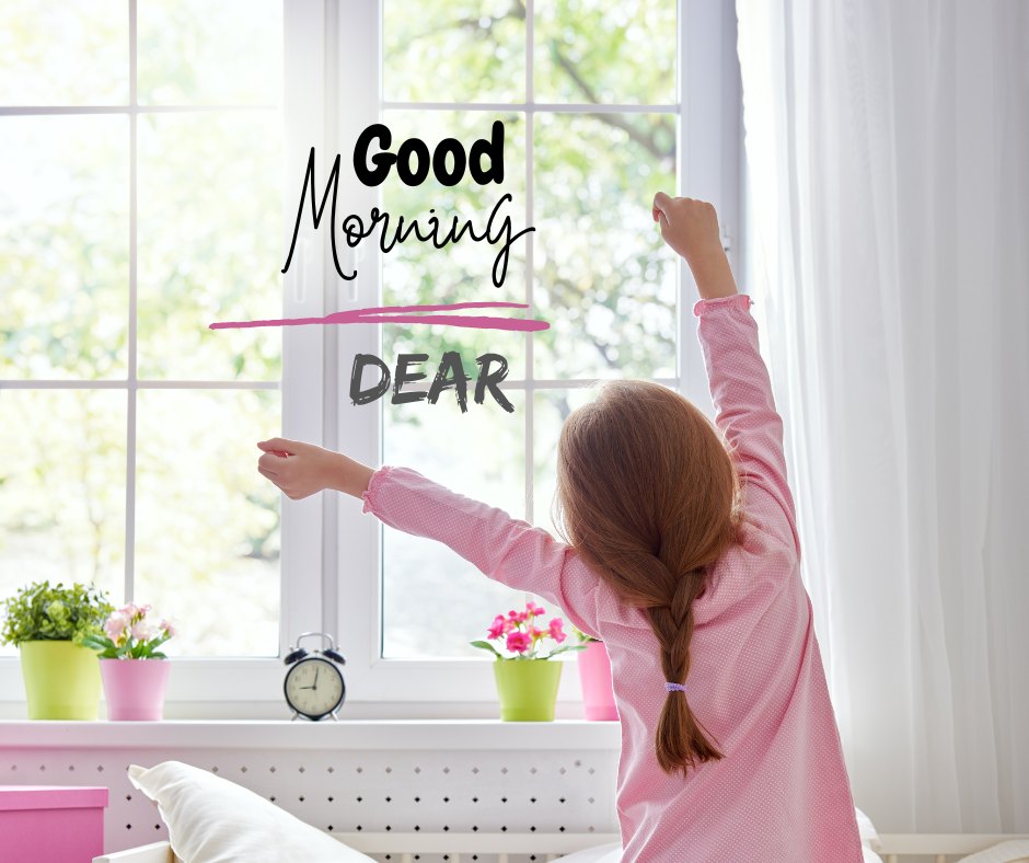 Good morning dear image featuring a young girl stretching joyfully in her pink pajamas by a sunny window, surrounded by colorful flowers, with 'Good Morning DEAR' text creatively displayed above.