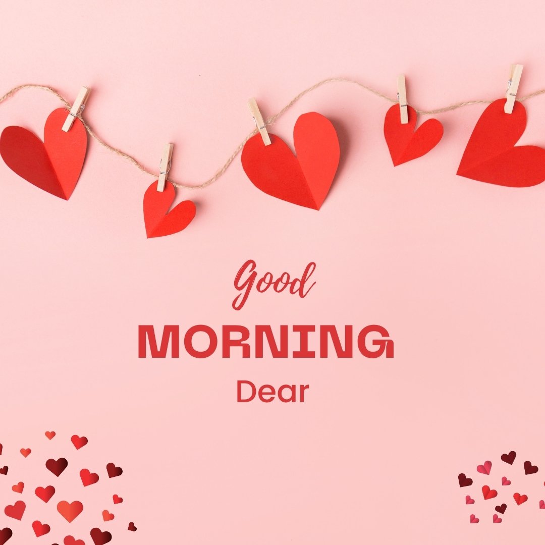 Good morning dear image showcasing a charming display of red paper hearts of varying sizes hung on a twine with clothespins against a soft pink background, with the greeting 'Good Morning Dear' elegantly scripted below.