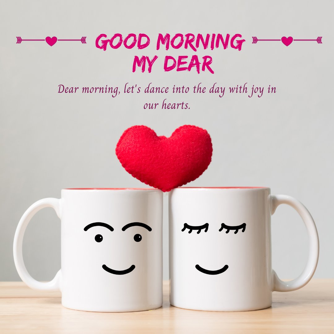 Good morning dear image featuring two white coffee mugs with smiling faces and a plush red heart between them on a wooden table, expressing affection and joy.