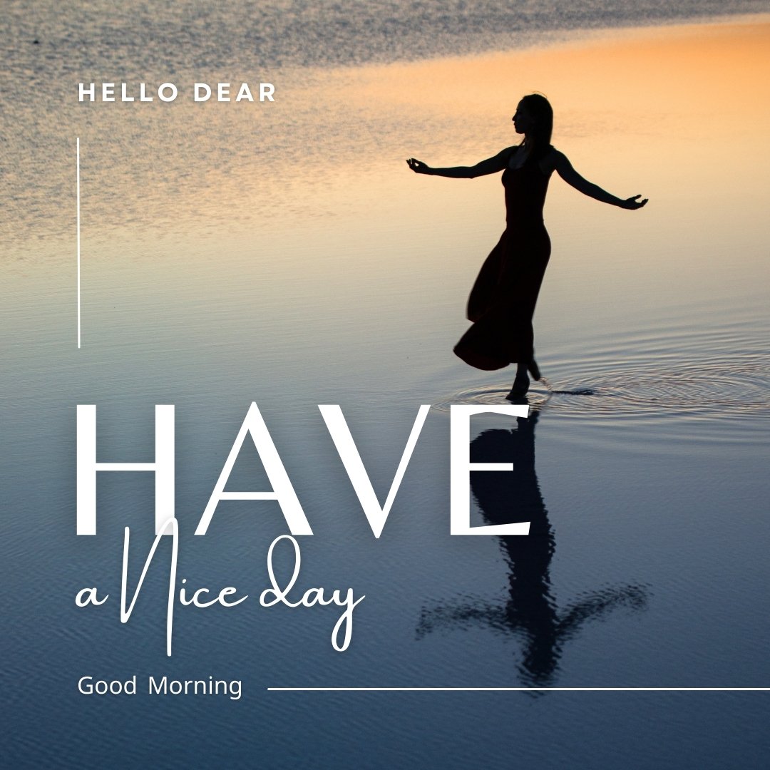 Good morning dear images of a serene sunrise scene with a woman silhouetted against a calm lake. The soft hues of dawn reflect on the water as she spreads her arms, embodying peace and freedom. The text 'Hello Dear, Have a Nice Day' complements the uplifting morning mood.