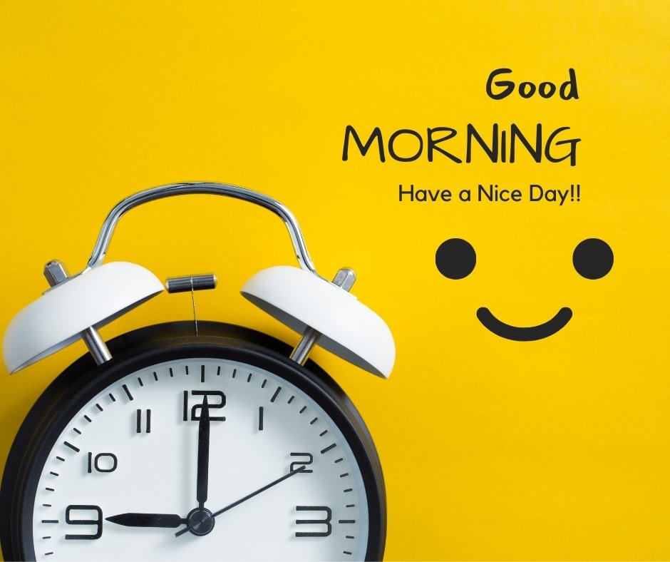 A black and white alarm clock set at 10:11 is in the lower left corner against a bright yellow background. Above and to the right, the text reads "Good MORNING Have a Nice Day!!" accompanied by a simple smiley face. This cheerful image is perfect for starting your day with positivity.