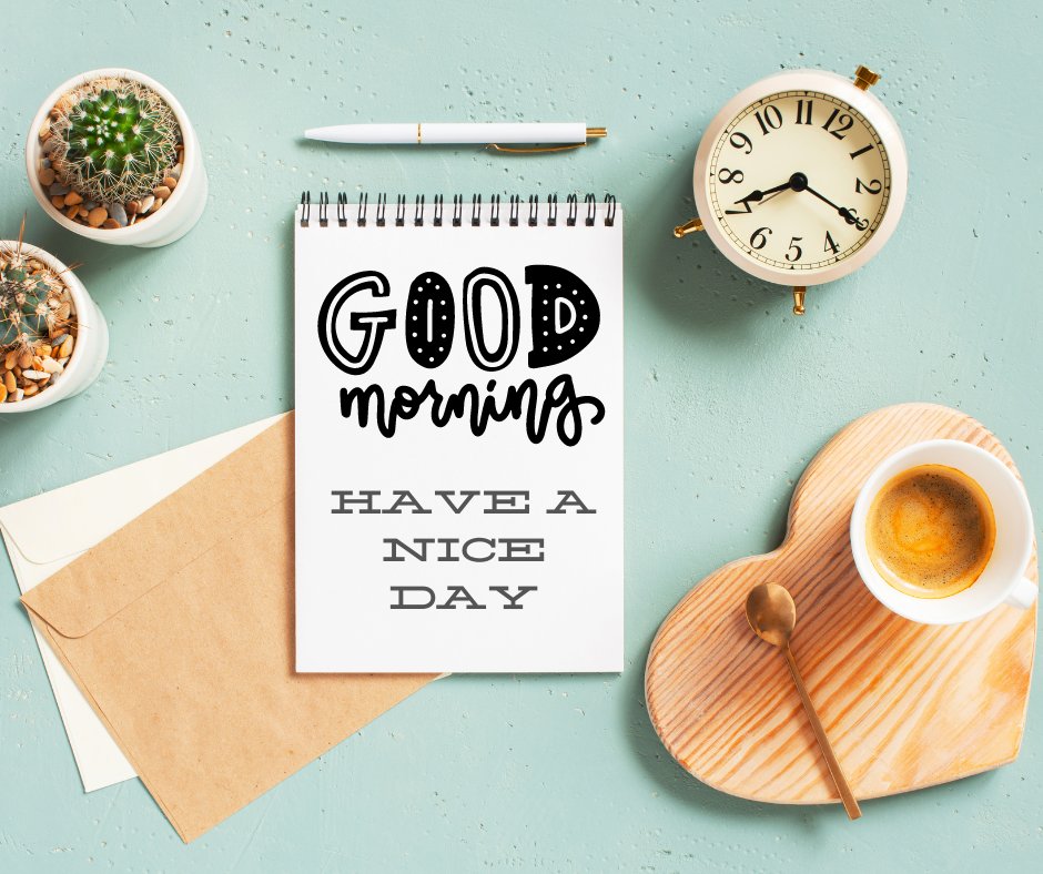 A desk with a notepad that reads "Good Morning, Have a Nice Day," accompanied by a pen, an envelope, potted plants, an alarm clock, and a cup of coffee with a spoon on a wooden heart-shaped coaster. The background is adorned with light teal images and accents.